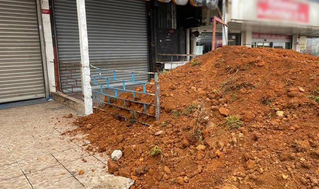 İstediği kirayı alamayan ev sahibi dükkanın önünü kumla kapattı