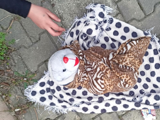 Kundağa sarılı bez oyuncak ile dilencilik yaparken yakalandı