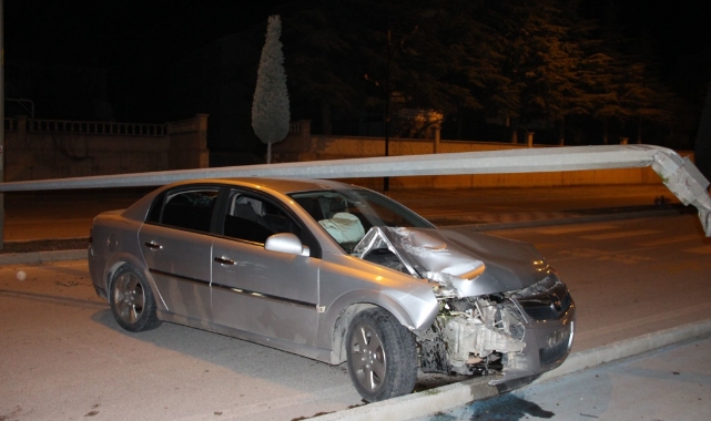 Çarptığı direk otomobilin üzerine devrildi