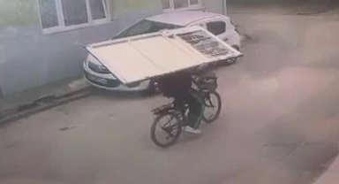 Sırtladığı kapıyı bisikletle böyle taşıdı