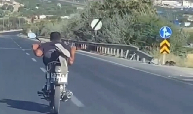 Trafikte tehlikeli anlar! Motosikleti yüzüstü uzanarak kullandı