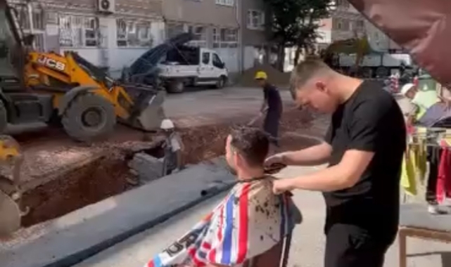 Hem traş oldu hem de yol yapım çalışmasını izledi