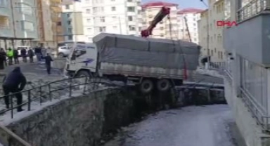 Buzda kayan kamyon, derenin duvarında asılı kaldı