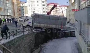 Buzda kayan kamyon, derenin duvarında asılı kaldı