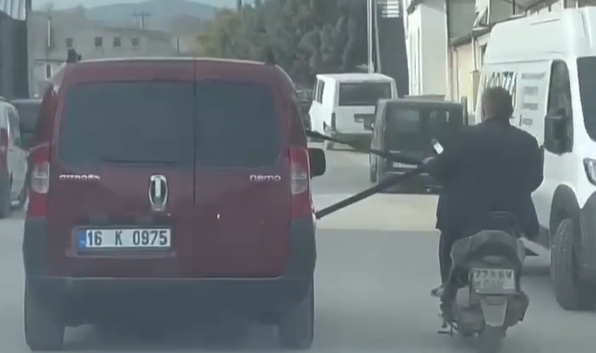 Emniyet kemerine tutunarak motosiklet çektiler